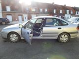 a silver car with its door open in a parking lot