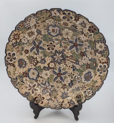 a decorative plate with a floral design on a stand