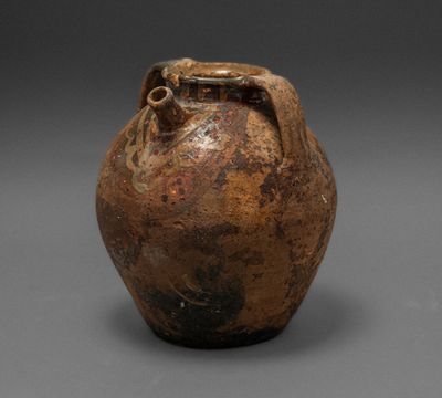 an old brown vase sitting on top of a gray surface