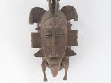 une image d'un masque en bois accroché au mur