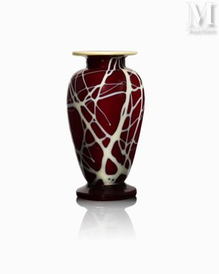 un vase rouge orné d'un motif blanc et noir