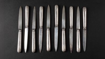 six knives are lined up in a row on a black surface