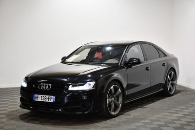 the black audi is parked in a large room with checkered floor