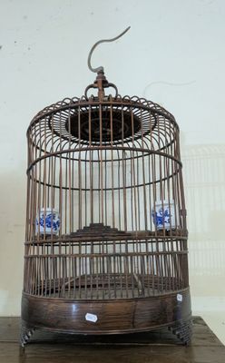 a bird in a cage that is on a table