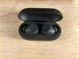 a close up of a pair of black earphones on a wooden surface