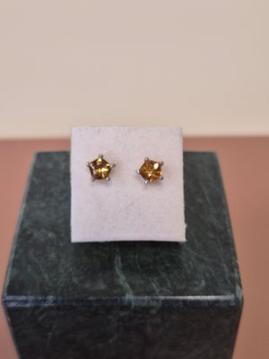 une paire de boucles d'oreilles en or posée sur un bloc de marbre