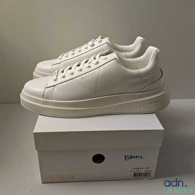 les baskets blanches sont posées sur une boîte blanche