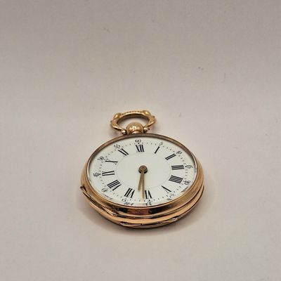 une montre de poche en or avec des chiffres romains