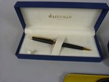 a box with a pen and a watch inside of it