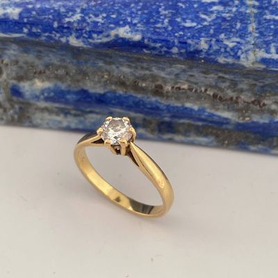 a yellow gold engagement ring with a diamond in the center