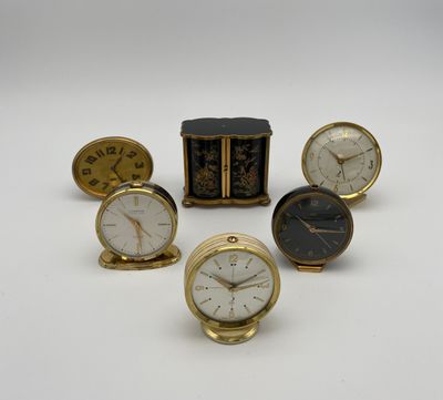 plusieurs types d'horloges posées sur une surface blanche
