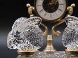 two crystal figurines sitting on top of a glass table