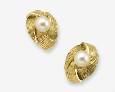 une paire de boucles d'oreilles en perles et en or sur fond blanc