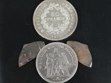 deux pièces d'argent et un couteau posés sur une surface noire