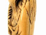 an old carved figurine of a man with a hat on his head