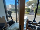 une pièce équipée d'appareils de musculation et dotée d'une grande fenêtre