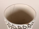a white cup with a black design on it