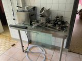 une table sur laquelle sont posés tout un tas de casseroles et de poêles
