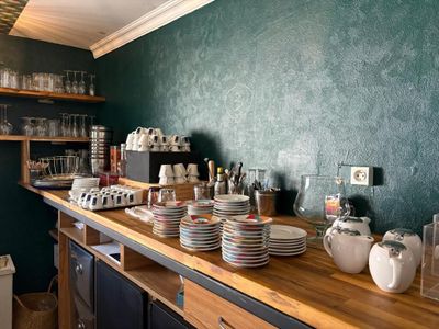 many plates and cups on the counter in the kitchen