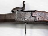a close up of a gun on a table with a white background