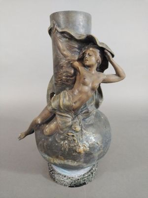 une statue représentant une femme assise sur un vase