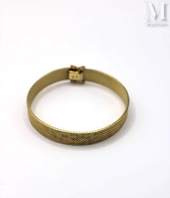 a close up of a gold bracelet on a white surface