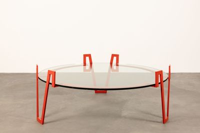 an image of a glass table with orange legs and a glass top