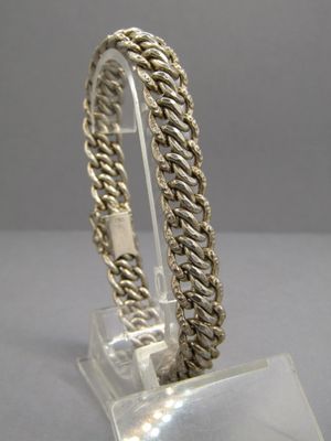 bracelet en argent sterling posé sur un support en acrylique transparent avec une base en acrylique transparent