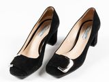 une paire d'escarpins en daim noir avec une boucle métallique