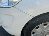 a small white car parked on the side of the road