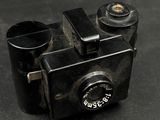 a black camera on a table with a black background