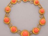 a gold and coral colored bracelet