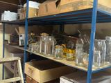 a shelf of empty glass bottles and boxes in a room