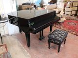 a piano and a stool in a room with a lot of furniture