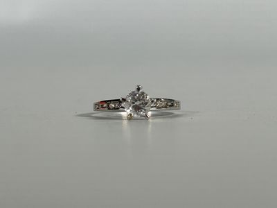 a close up of a diamond ring on a white surface