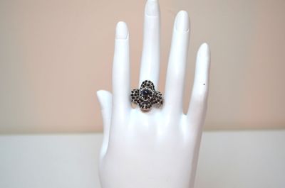 a ring that is sitting on a mannequin ' s hand