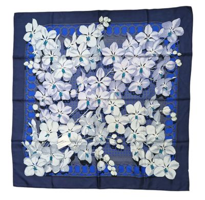 un foulard carré bleu et blanc orné de fleurs blanches