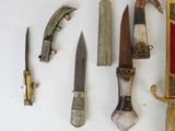 many different types of knives and knives laid out on a table