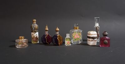 sept petites bouteilles de différentes couleurs et tailles posées sur une table