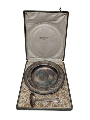 un ancien service en argent présenté dans un coffret contenant une cuillère et un repose-cuillère