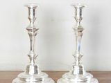 two silver candlesticks sitting on a wooden table