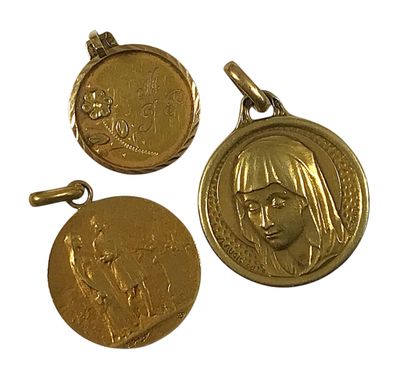 trois médailles d'or représentant un visage de femme et une tête d'homme