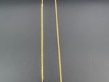 un collier en or orné d'une pierre rose et d'une chaîne en or