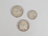 three different types of coins are shown on a white surface