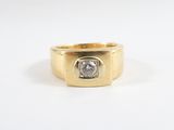 a close up of a gold ring with a diamond in the center