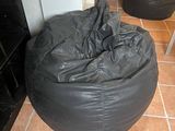 a black bean bag sitting on the floor in a room