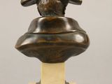 a bronze bust of a man wearing a hat on a pedestal