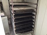 a lot of trays that are on a rack in the kitchen