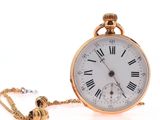 a gold pocket watch with roman numerals on it