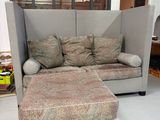 a couch and ottoman in a room with a window